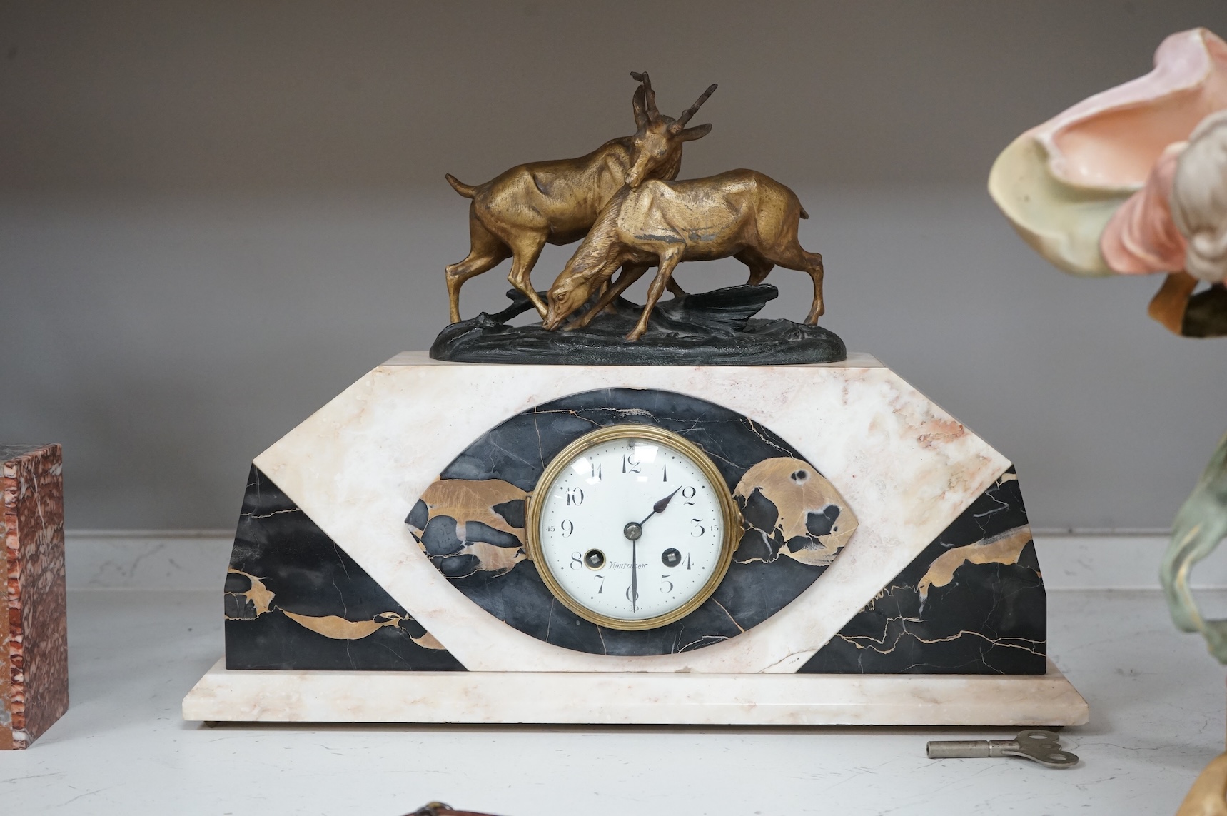An Art Deco marble clock garniture and a French clock surmounted with two deer, with key, 44cm wide